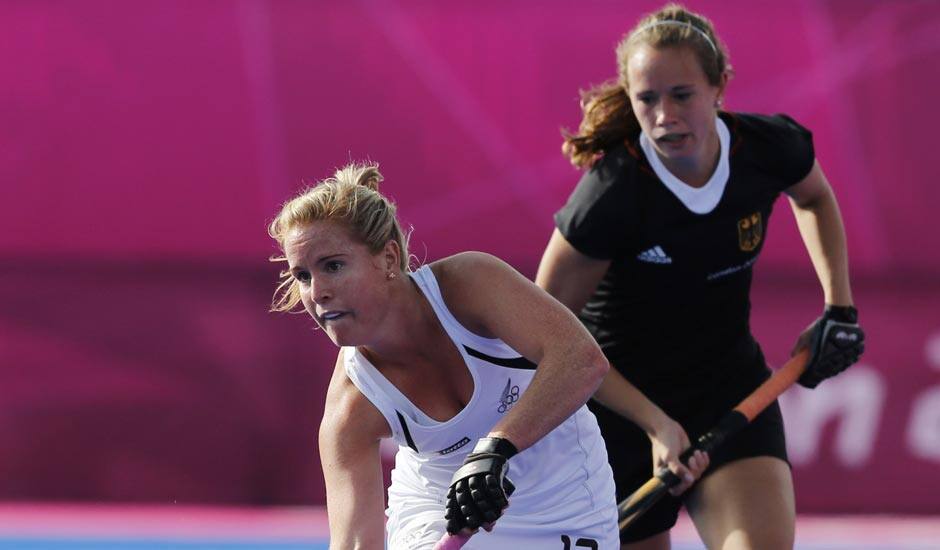 New Zealand's Ella Gunson, front, plays a shot as Germany's Celine Wild watches in their preliminary round women's hockey match at the 2012 Summer Olympics.