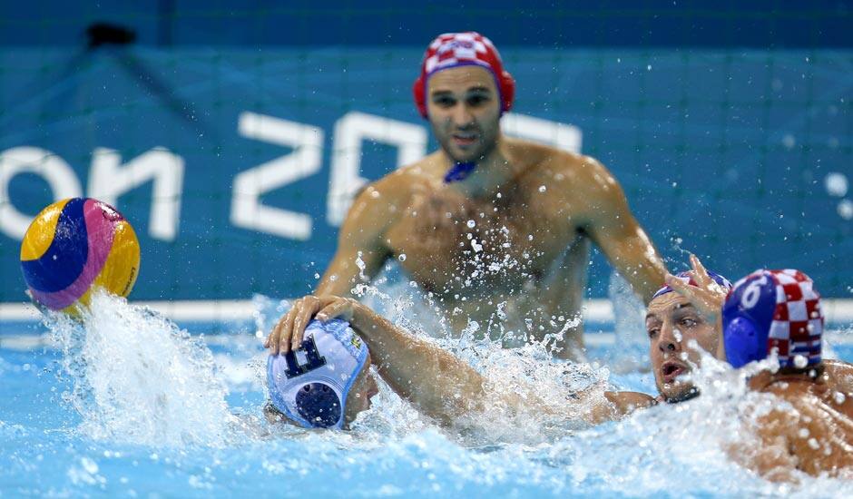 Andro Buslje, center right, of Croatia puts his hand on Ravil Manafov, left, of Kazakhstan as Croatia's Josip Pavic, back, Ivan Buljubasic defend during a preliminary men's water polo match at the 2012 Summer Olympics.