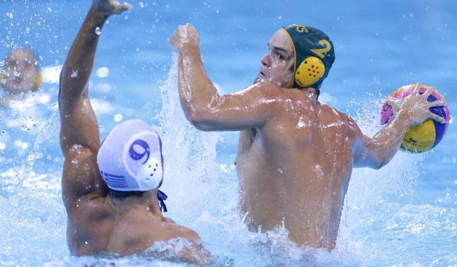 Richie Campbell of Australia takes a shot at goal as Georgios Afroudakis of Greece goes to block the attempt during their men's water polo preliminary round match at the 2012 Summer Olympics.