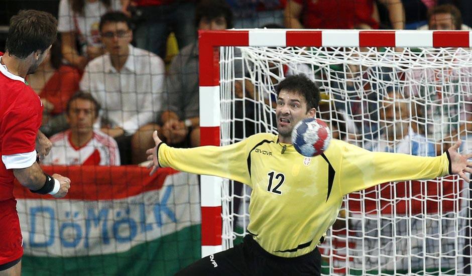 Serbia's Darko Stanic, right, fails to save a shot by Hungary's Tamas Mocsai, left, during their men's handball preliminary match at the 2012 Summer Olympics.