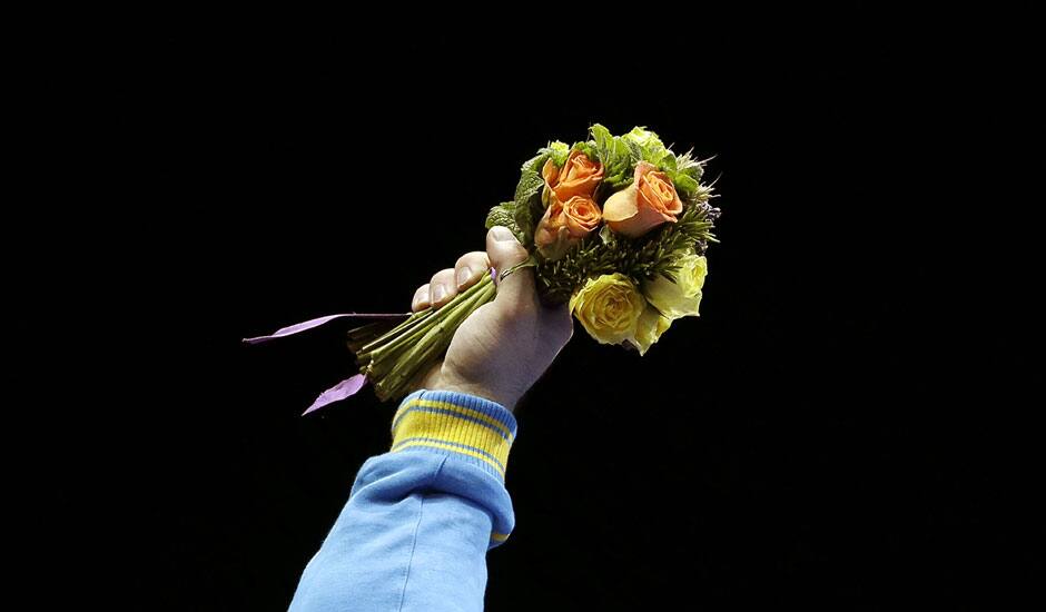 Gold medalist Oleksiy Torokhtiy of Ukraine, holds up the flowers during the awards presentation after the men's 105-kg weightlifting competition at the 2012 Summer Olympics