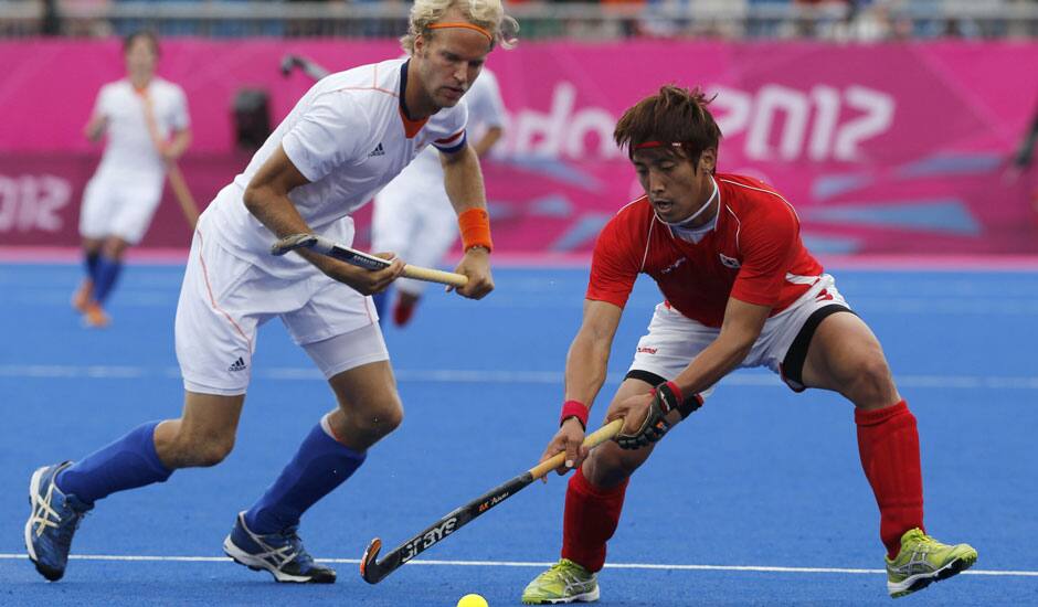 Netherlands' Floris Evers, and South Korea's Jang Jong-hyun vie for the ball in the preliminary round hockey match at the 2012 Summer Olympics in London. 