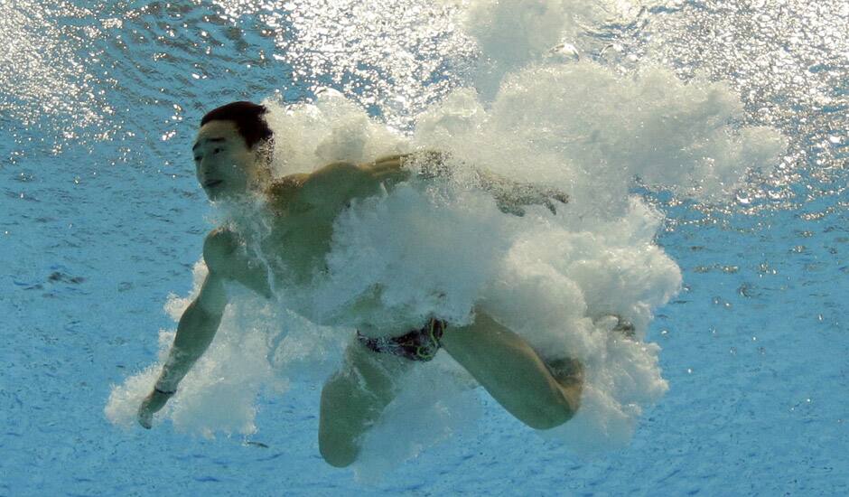 Qin Kai of China dives during the men's 3-meter springboard diving semifinal at the Aquatics Centre in the Olympic Park during the 2012 Summer Olympics in London.