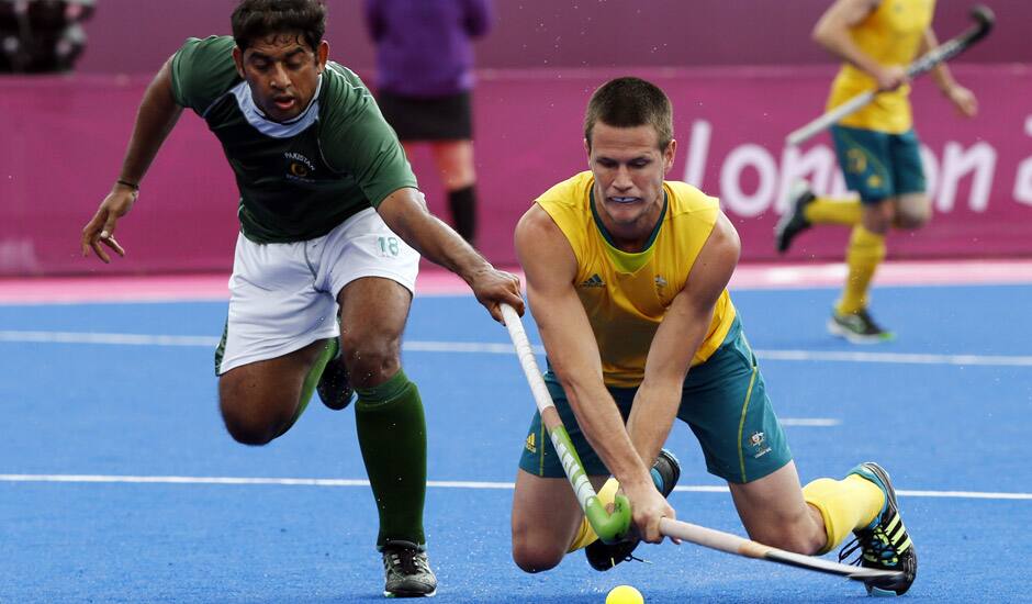 Pakistan's Muhammad Imran, and Australia's Matt Gohdes vie for the ball in their preliminary round hockey match at the 2012 Summer Olympics in London. 