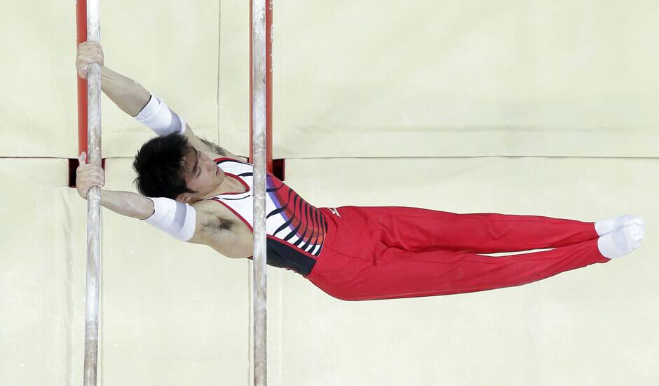 Japanese gymnast Kazuhito Tanaka performs on the parallel bars during the artistic gymnastics men's apparatus finals at the 2012 Summer Olympics in London.