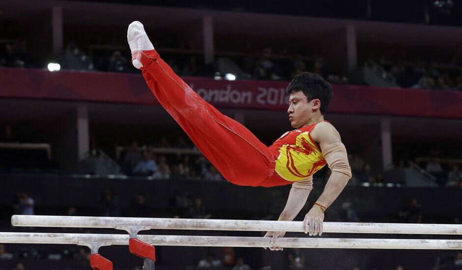 Chinese gymnast Feng Zhe performs on the parallel bars during the artistic gymnastics men's apparatus finals at the 2012 Summer Olympics in London. 