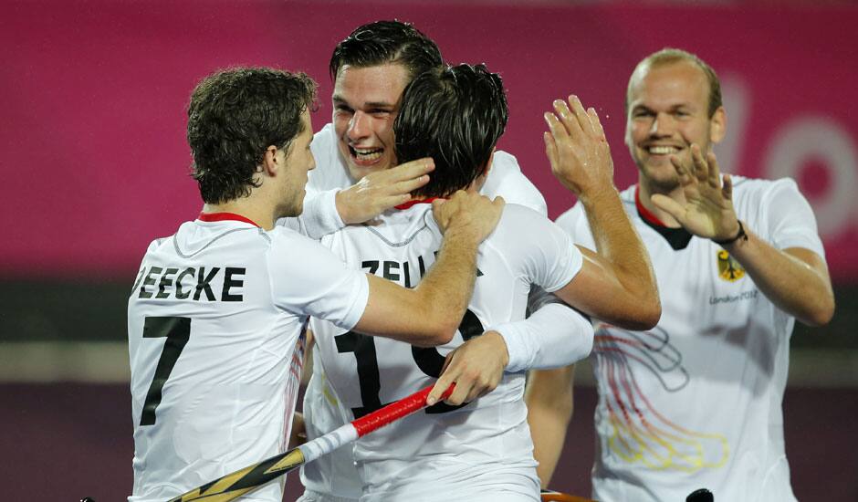 German players congratulate their teammate Christopher Zeller, center back facing camera, for scoring a goal against New Zealand during a preliminary round men's hockey match at the 2012 Summer Olympics.