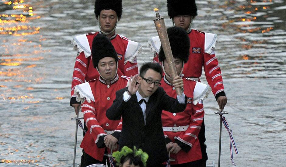 Yin Guangheng, center, holds a torch on a speedboat while being ferried to make a marriage proposal to his girlfriend at a park in Nanjing, in eastern China's Jiangsu province.