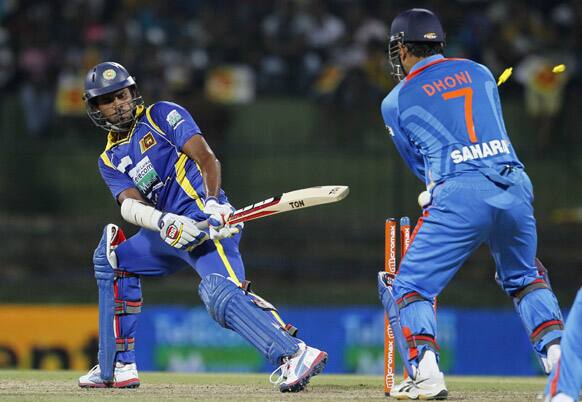 Lahiru Thirimanne loses his wicket as India's captain Mahendra Singh Dhoni looks on during a Twenty20 cricket match between India and Sri Lanka in Pallekele.