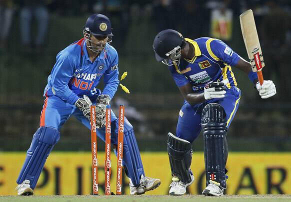 Mahendra Singh Dhoni removes the bails unsuccessfully attempting for a stump against Sri Lanka's batsman Angelo Mathews during a Twenty20 cricket match between India and Sri Lanka in Pallekele.