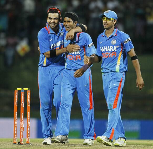 Ashok Dinda celebrates the dismissal of Sri Lanka's batsman Lasith Malinga, unseen, with Virat Kohli and Manoj Tiwary as India beat Sri Lanka in the one-off Twenty20 cricket match in Pallekele.