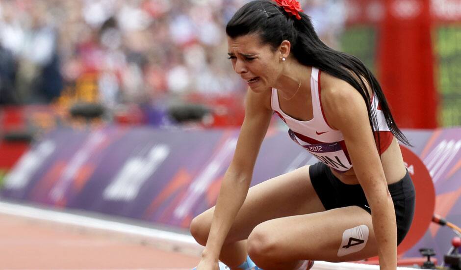 Turkey's Merve Aydin sits down after the finish line in a women's 800-meter heat during the athletics in the Olympic Stadium at the 2012 Summer Olympics in London