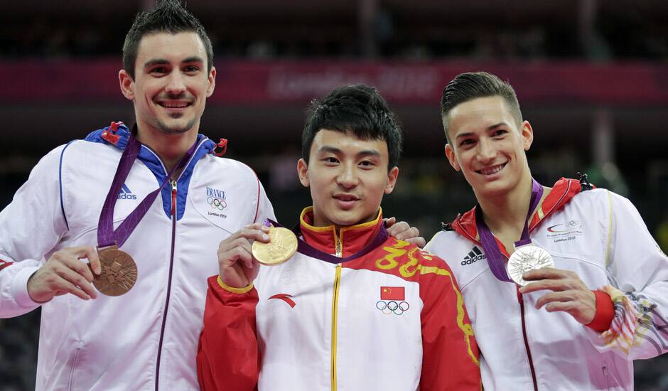 Chinese gold medallist gymnast Feng Zhe, center, Germany's silver medallist Marcel Nguyen, right, and bronze medallist Hamilton Sabot from France display their medals for the parallel bars during the artistic gymnastics men's apparatus finals at the 2012 Summer Olympics.