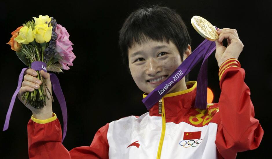 Gold medalist China's Wu Jingyu celebrates on the podium during the medal ceremony for the women's 49-kg taekwondo competition at the 2012 Summer Olympics.