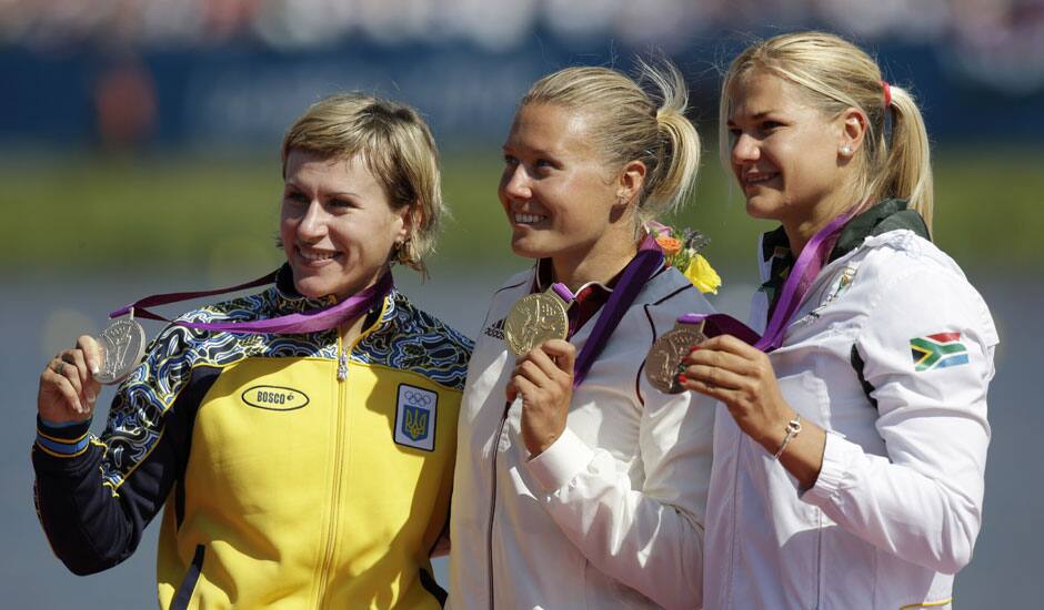 Winners of the women's kayak single 500m pose on the podium in Eton Dorney, near Windsor, England, at the 2012 Summer Olympics. From left to right, Ukraine's Inna Osypenko-Radomska, silver medal, Hungary's Danula Kozak, gold medal and South Africa's Bridgitte Hartley, bronze.