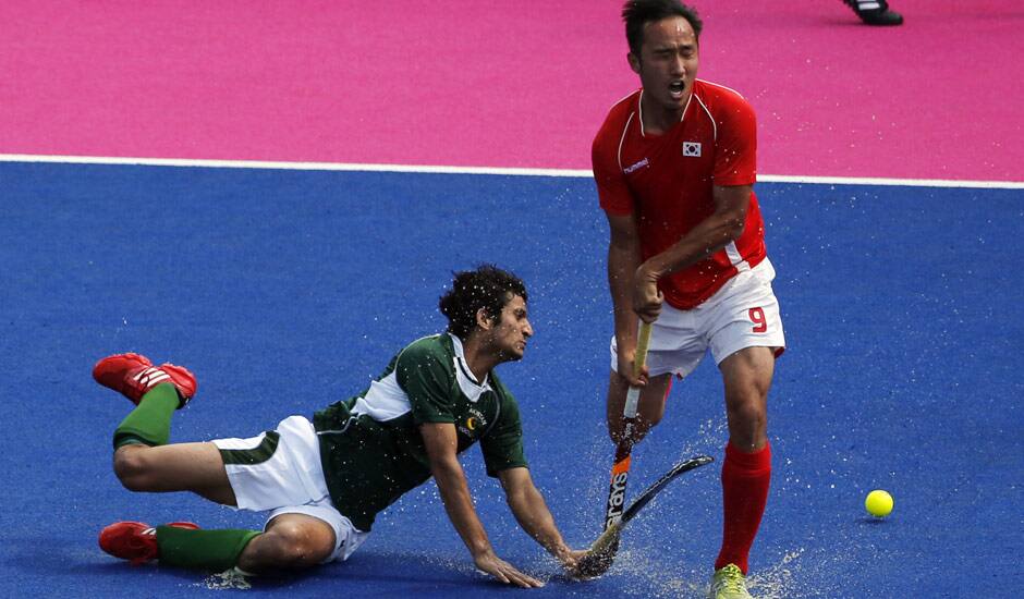 Pakistan's Muhammad Rizwan Jr, and South Korea's Yoon Sung-hoon vie for the ball in their hockey classification match at the 2012 Summer Olympics in London.