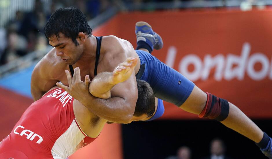 anada's Matthew Judah Gentry, in red, and India's Narsingh Pancham Yadav, in blue, compete during a 74-kg men's freestyle wrestling competition at the 2012 Summer Olympics in London.