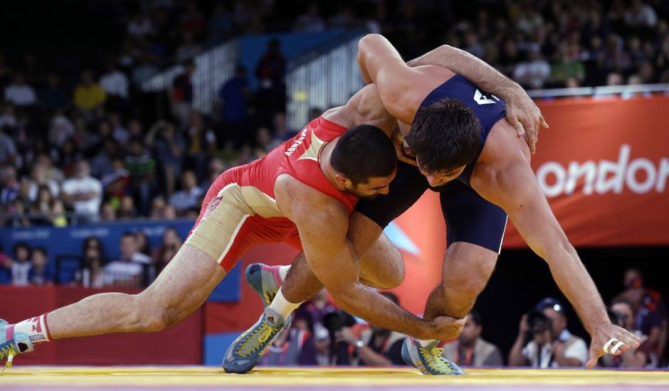 Bilyal Makhov of Russia competes against Jamaladdin Magomedov of Azerbaijan (in blue) during the men's 120-kg freestyle wrestling competition at the 2012 Summer Olympics.