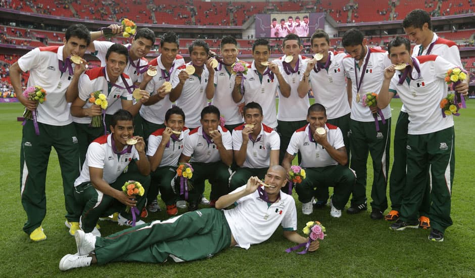 Mexican players pose for photos with their gold medals after winning the men's soccer final against Brazil at the 2012 Summer Olympics in London