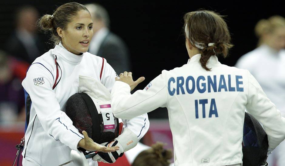 Elodie Clouvel from France, left, and Sabrina Grognale from Italy, right, shake hands after their bout during the fencing competition as part of the modern pentathlon at the Copper Box in the Olympic Park during the 2012 Summer Olympics.