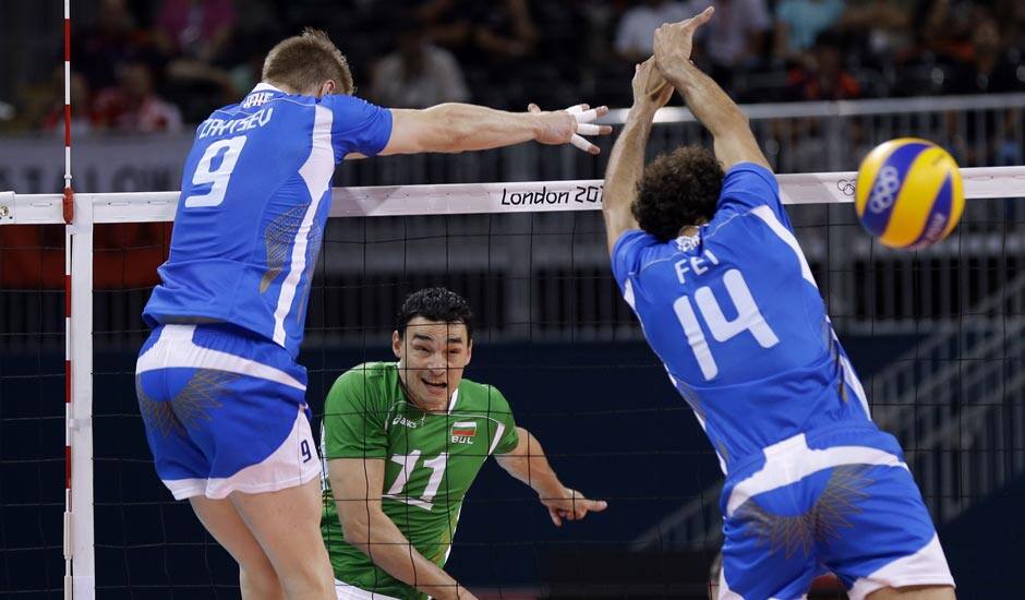 Bulgaria's Vladimir Nikolov (11) follows his spike as it gets past Italy defenders Ivan Zaytsev (9) and Alessandro Fei (14) during a men's volleyball bronze medal match at the 2012 Summer Olympics.