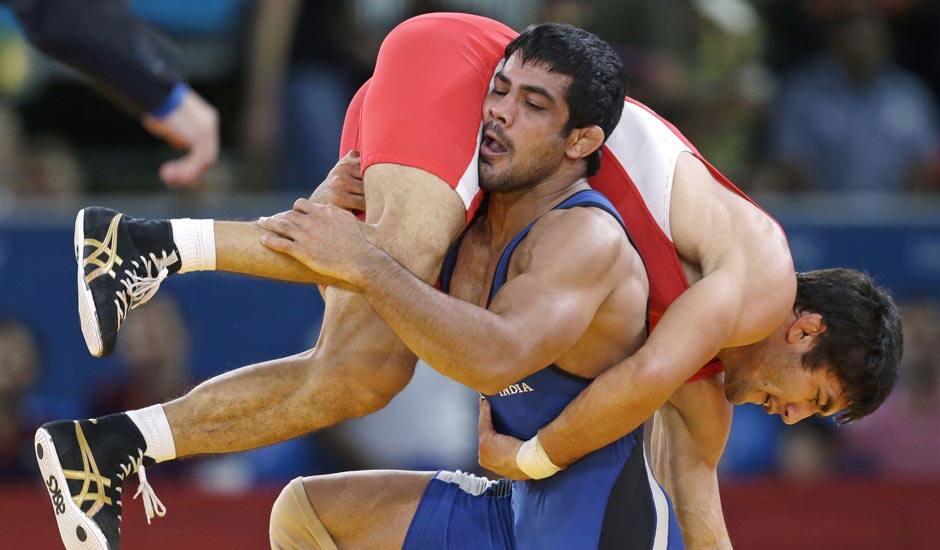 Ikhtiyor Navruzov of Uzbekistan, competes with Sushil Kumar of India, (in blue) during their 66-kg freestyle wrestling match at the 2012 Summer Olympics.