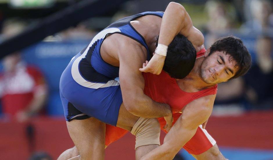 Ikhtiyor Navruzov, competes with Sushil Kumar of India, (in blue) during their 66-kg freestyle wrestling match at the 2012 Summer Olympics.