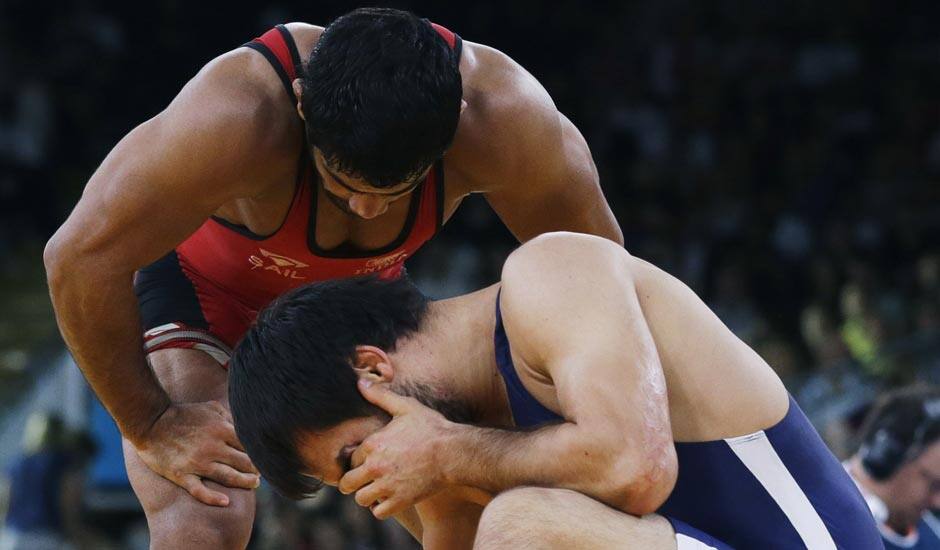 Ikhtiyor Navruzov of Uzbekistan, competes with Sushil Kumar, (in blue) during their 66-kg freestyle wrestling match at the 2012 Summer Olympics.