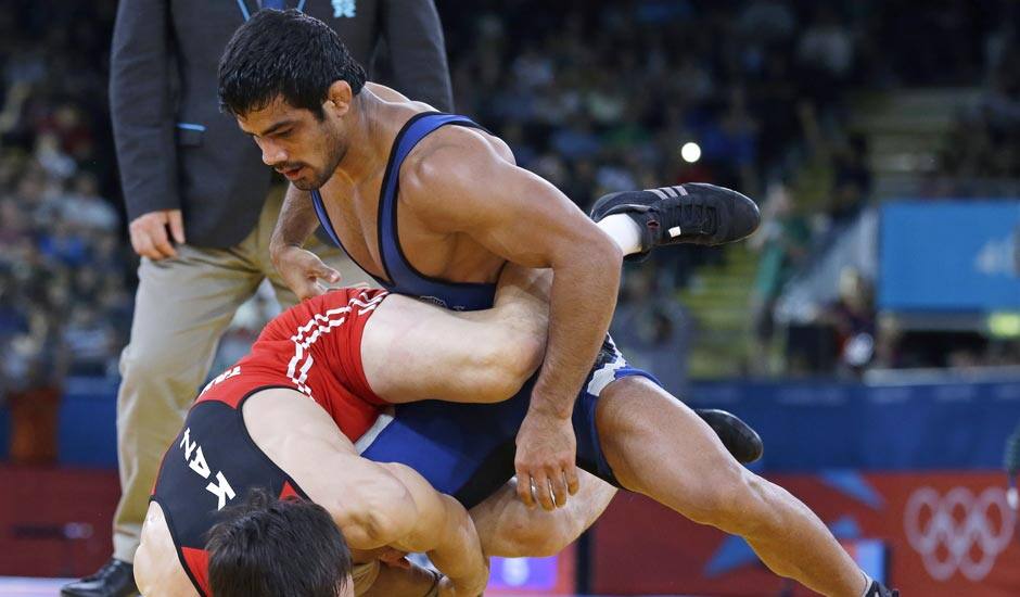 Akzhurek Tanatarov of Kazakhstan, competes with Sushil Kumar of India, (in blue) during their 66-kg freestyle wrestling match at the 2012 Summer Olympics.