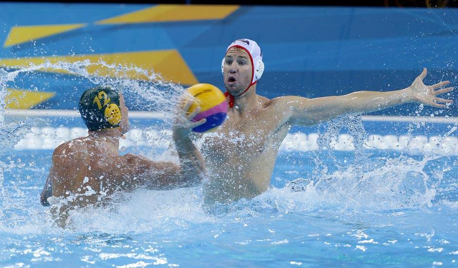 Billy Miller of Australia, left, shoots at goal as Layne Beaubien of the United States attempts to block during the men's water polo seventh place match at the 2012 Summer Olympics.