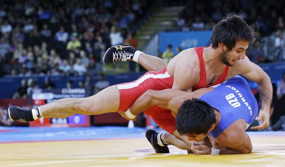 Ramazan Sahin of Turkey competes with Ikhtiyor Navruzov of Uzbekistan (in blue) during their 66-kg freestyle wrestling match at the 2012 Summer Olympics.