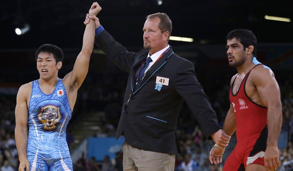 Tatsuhiro Yonemitsu of Japan celebrates after defeating Sushil Kumar of India, right, in the 66-kg freestyle wrestling gold medal match at the 2012 Summer Olympics.