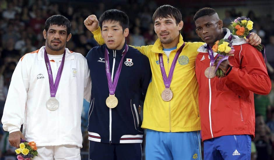 Silver medalist Sushil Kumar, gold medalist Tatsuhiro Yonemitsu of Japan, bronze medalist Akzhurek Tanatarov of Kazakhstan, and bronze medalist Livan Lopez Azcuy of Cuba, participate in the medals ceremony for men's 66-kg freestyle wrestling at the 2012 Summer Olympics.