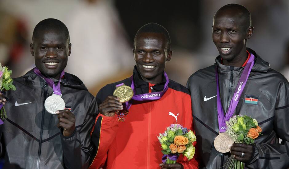 Men's marathon gold medalist Uganda's Stephen Kiprotich, center, is flanked by silver medalist Abel Kirui, of Kenya, left, and bronze medalist Wilson Kipsang Kiprotich, at the 2012 Summer Olympics, Sunday, Aug. 12, 2012, in London. 