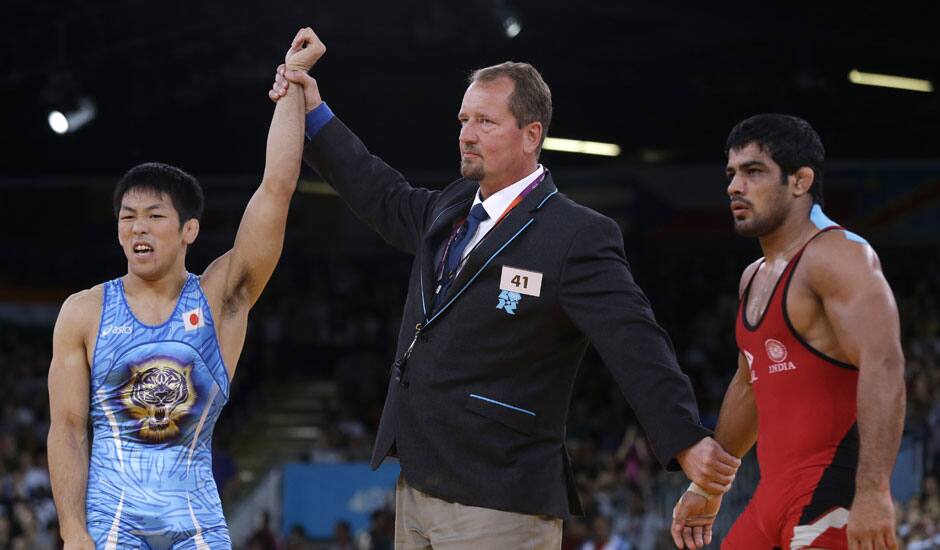 Tatsuhiro Yonemitsu of Japan celebrates after defeating Sushil Kumar of India, right, in the 66-kg freestyle wrestling gold medal match at the 2012 Summer Olympics.