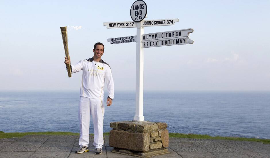 British Olympic sailing hero and three time gold medalist Ben Ainslie holds the Olympic torch at the official start of the London 2012 Olympic games torch relay at Land's End, south west England.