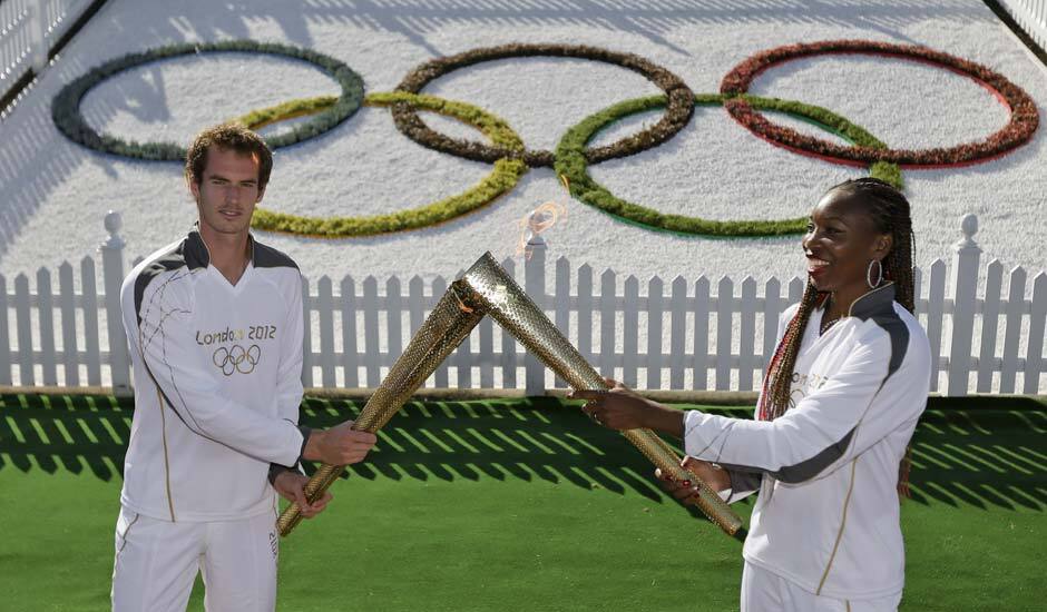 Scottish tennis player Andy Murray, hands over the Olympic flame to US tennis player Venus Williams at the All England Tennis Club in Wimbledon, ahead of the 2012 Summer Olympics.