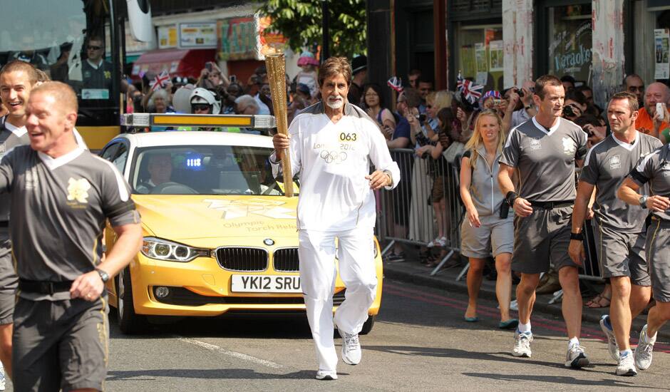 In this photo provided by LOCOG, Amitabh Bachchan carries the Olympic flame on the torch relay leg between The City of London and the borough of Southwark in London.