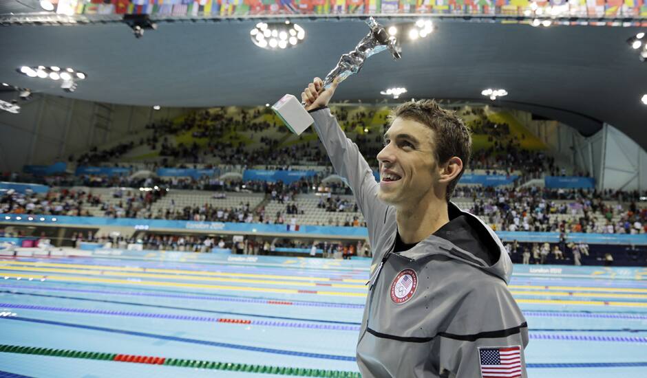 United States' swimmer Michael Phelps holds up a silver trophy after being honored as the most decorated Olympian at the Aquatics Centre in the Olympic Park during the 2012 Summer Olympics in London