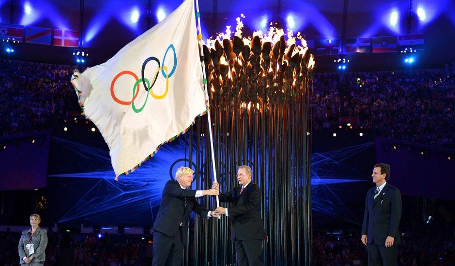 The Olympics flag is handed from London Mayor, Boris Johnson, second from left, to the International Olympic Committee President Jacques Rogge, as the Mayor of Rio de Janeiro, Eduardo Paes, right, watches during the Closing Ceremony of the 2012 Summer Olympic.