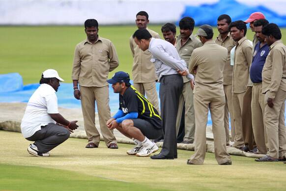 Mahendra Singh Dhoni talks to pitch curator Chandra Shekar, left, during a practice session in Hyderabad.