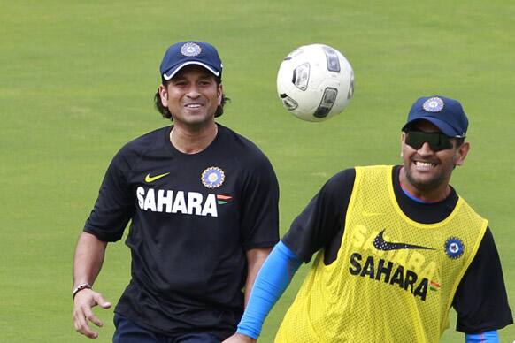 Sachin Tendulkar and captain Mahendra Singh Dhoni, vie for a soccer ball during a practice session in Hyderabad.