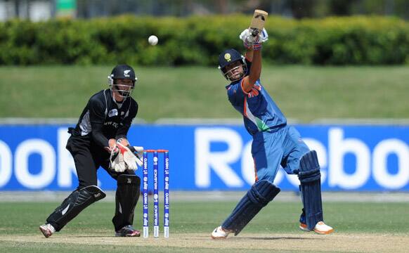 Prashant Chopra of India drives the ball as Cameron Fletcher of New Zealand stands over the stumps during their ICC U19 Cricket World Cup semi-final match in Townsville, Australia.