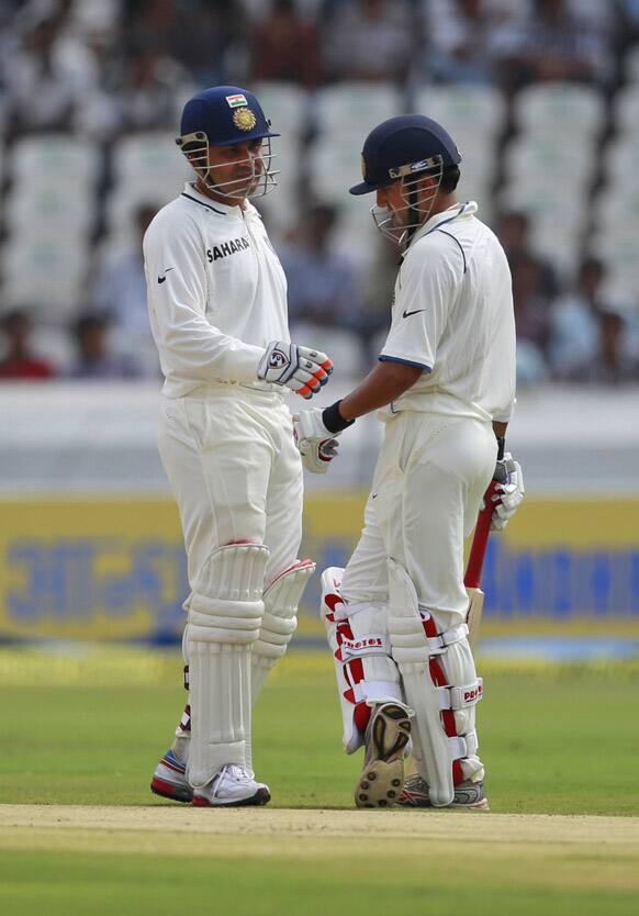 Gautam Gambhir and Virender Sehwag interact during the first day of the first test cricket match against New Zealand in Hyderabad.