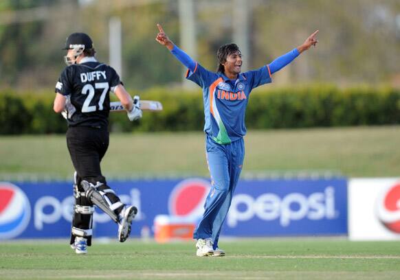 Kamal Passi, of India celebrates the run out a New Zealand batsman as Jacob Duffy, walks down the wicket during their ICC U19 Cricket World Cup semi-final match, in Townsville, Australia.