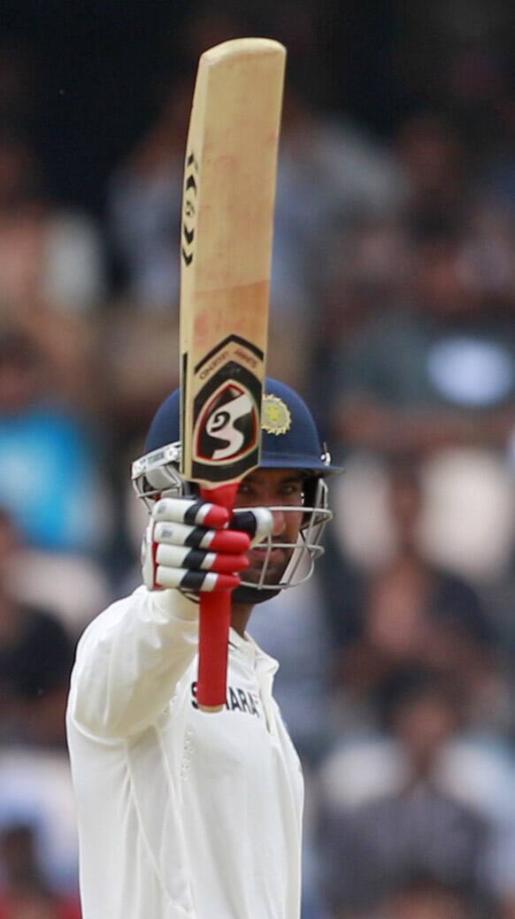 Pujara celebrates after scoring a half century during the first day of the first cricket test match against New Zealand in Hyderabad.