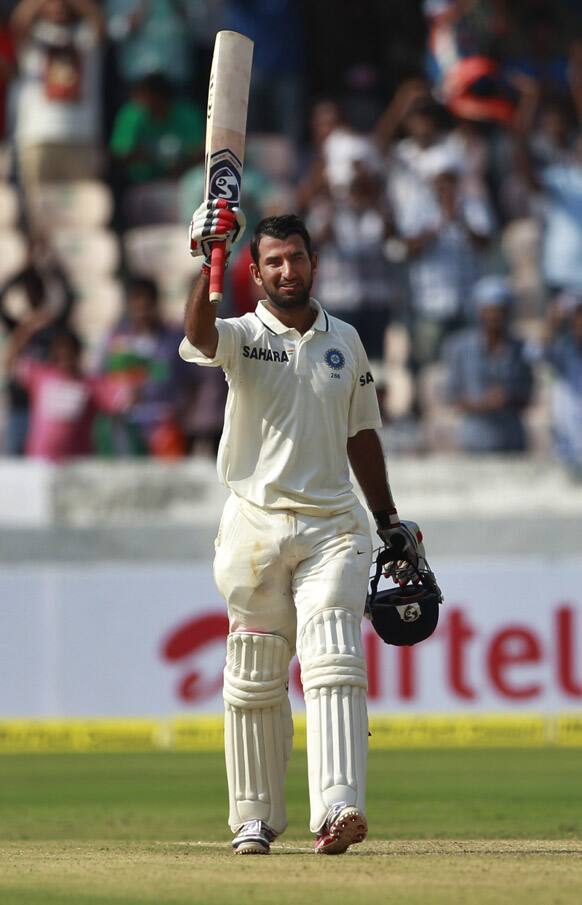 Cheteshwar Pujara celebrates after scoring a century during the first day of the first cricket test match against New Zealand in Hyderabad.