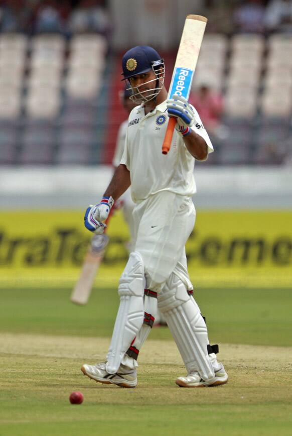 Mahendra Singh Dhoni celebrates after scoring a half century during the second day of the first cricket test match against New Zealand in Hyderabad.