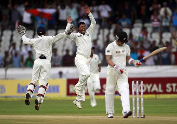 Pragyan Ojha, celebrates the wicket of New Zealand's Brendon McCullum, during their second day of the first cricket test match in Hyderabad.