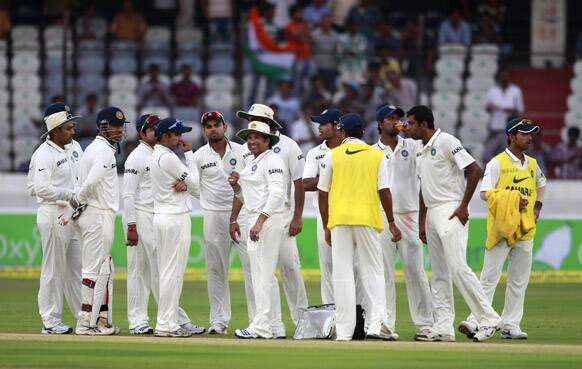 Mahendra Singh Dhoni, stands with teammates after the dismissal of New Zealand captain Ross Taylor by Ravichandran Ashwin, during the second day of the first cricket test match against New Zealand in Hyderabad.